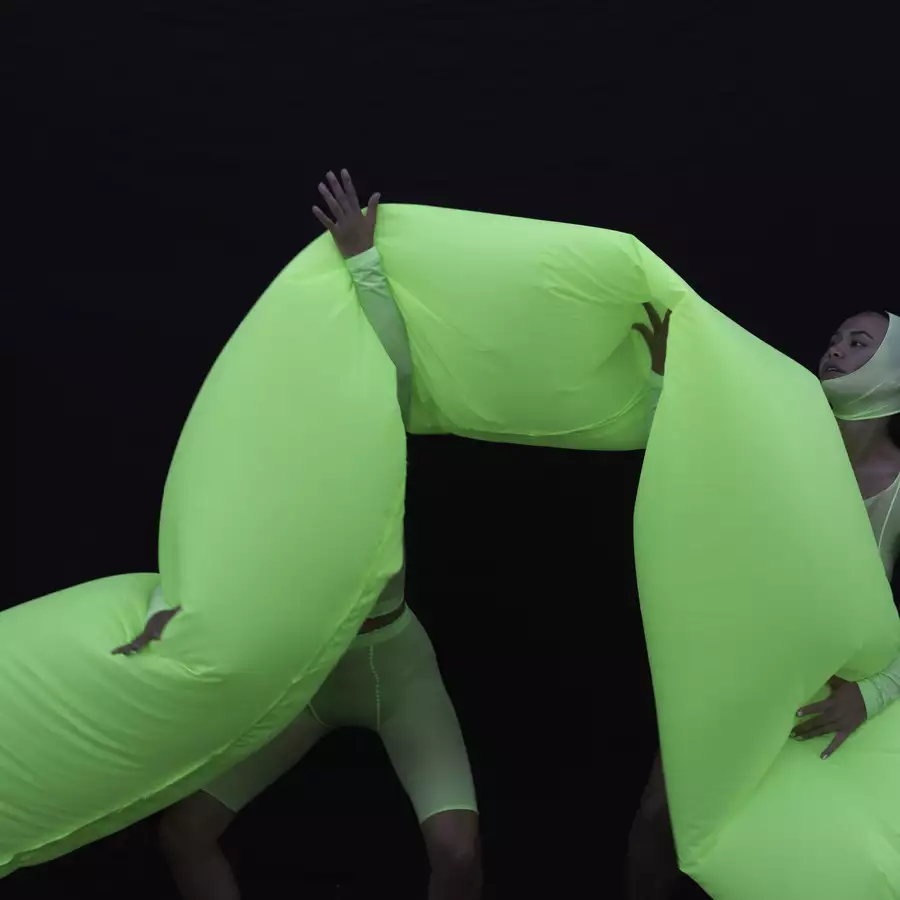 A large bright green inflatable tube held by two people