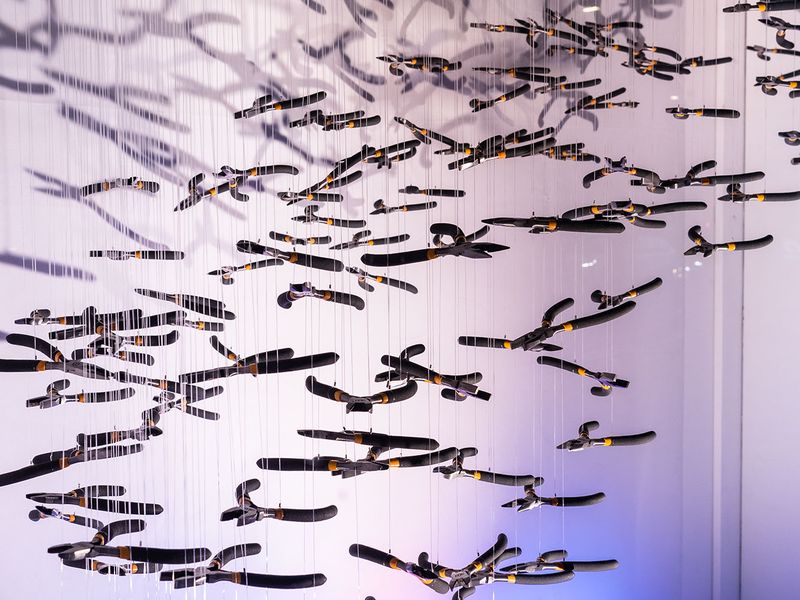 Installation of hundreds of jewellers pliers hanging in the formation of a murmuration of birds