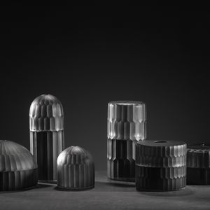 A composition of six objects with different shapes and sizes. All objects are black with a distinctive texture on a black background.