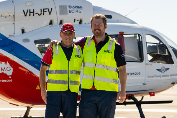 RFDS WA Pilot Jim and Doctor John pose in front of the RFDS WA FMG Helicopter