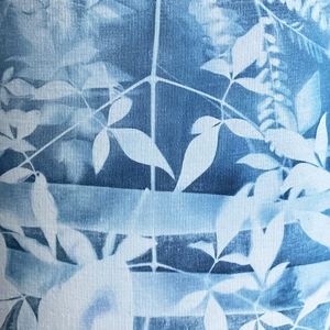 A detail of a blue and white cyanotype of flowers and leaves on a lampshade