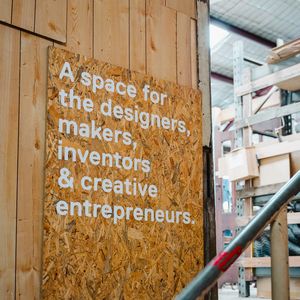 A wooden sign at a studio entrance that says - A space for the designers, makers, inventors & creative entrepreneurs