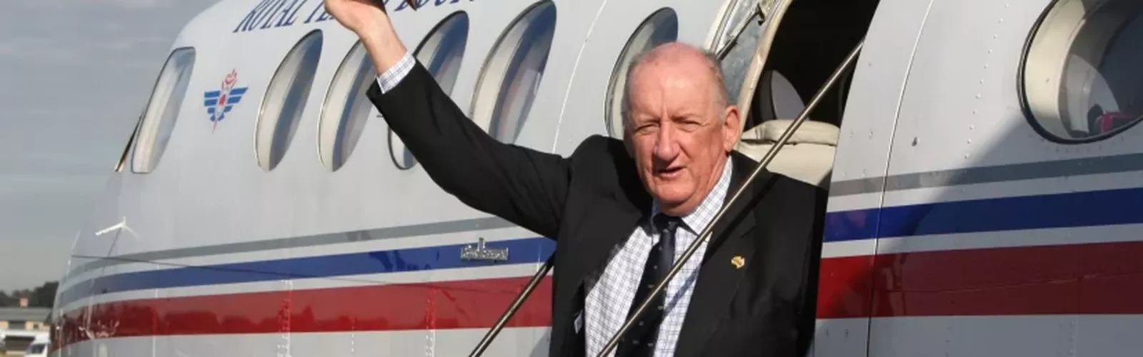 Tim Fischer sits on the steps of an RFDS plane