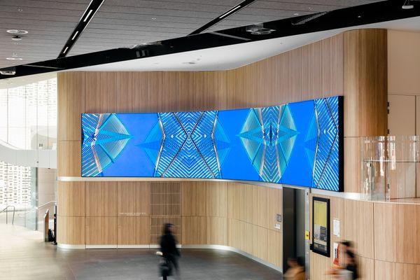 Image of a large digital screen with a grpahic blue and multicoloured image on it