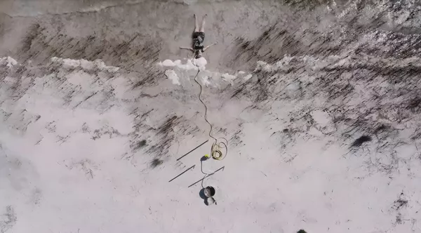 An aerial photo of a person laying on a sandy shore