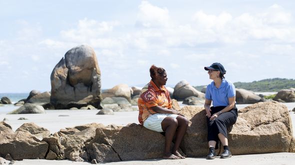 A patient talking to an RFDS staff member on the beach.