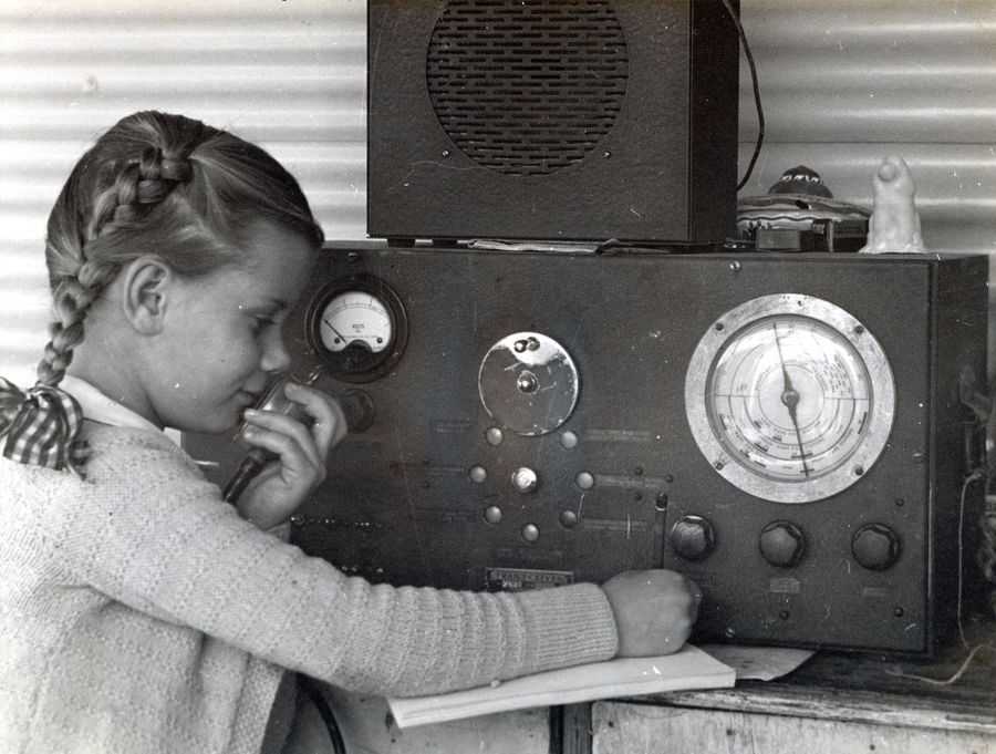 Young girl using radio for remote learning. 