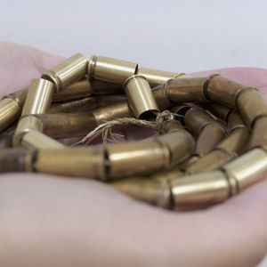 Brass Bullet casings threaded together and held in a persons palm