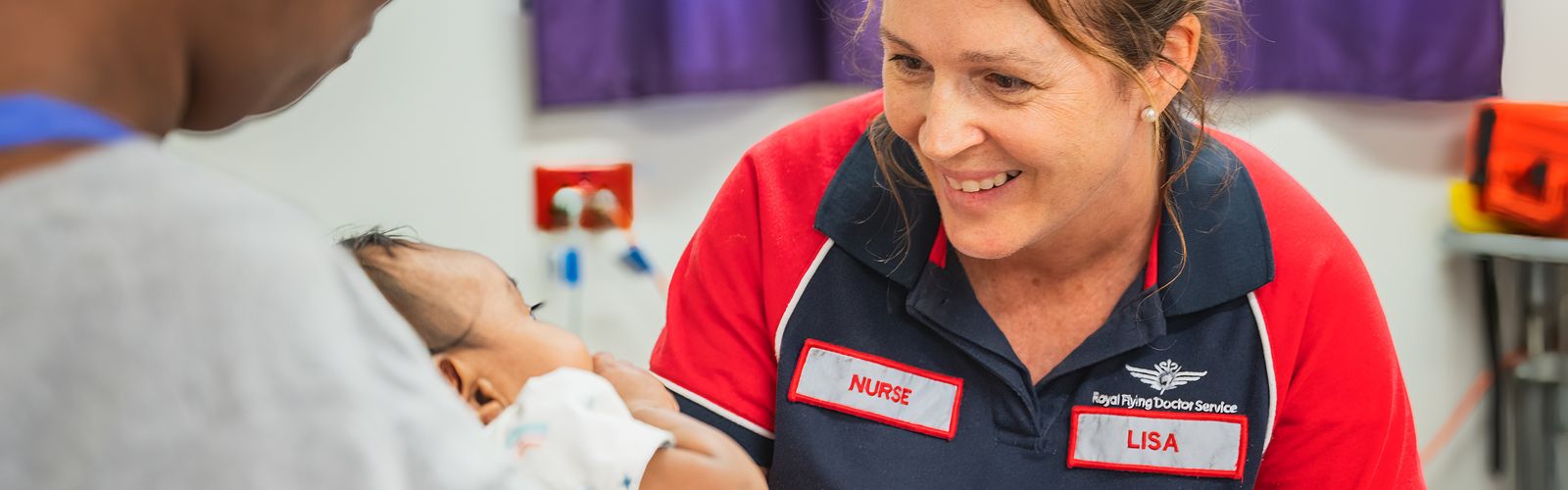 Nurse Lisa smiling at a baby in the clinic.
