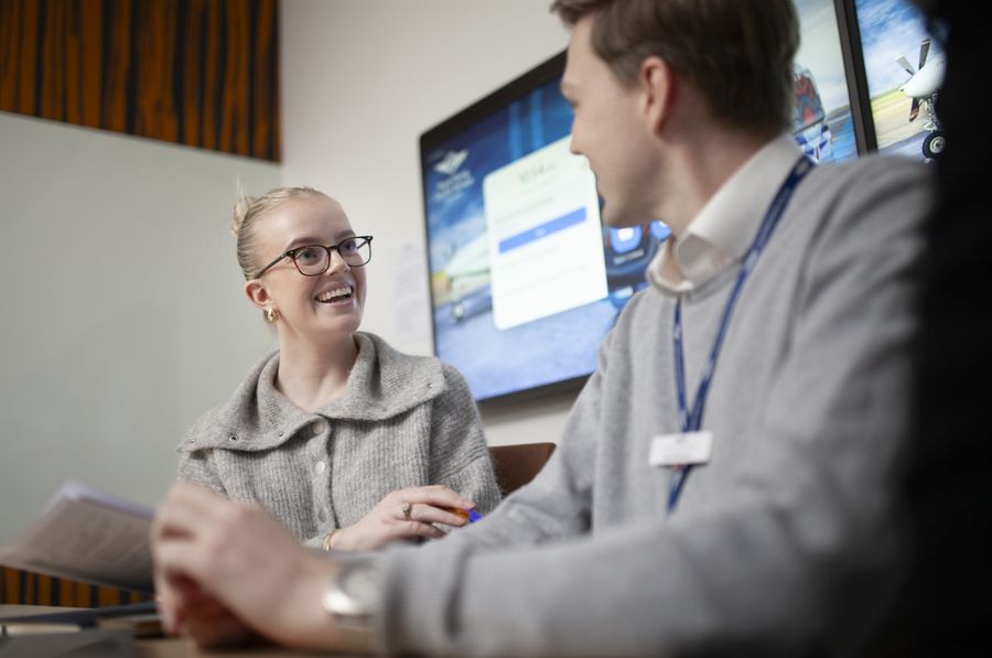 Two employees smiling at each other discussing RFDS workplace giving in an office setting