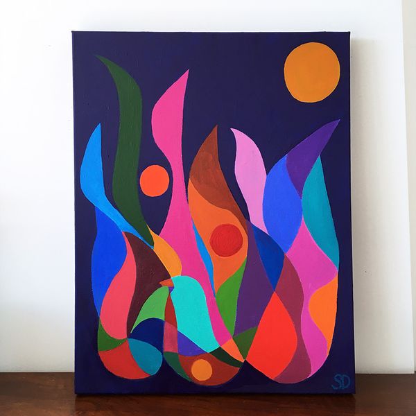 A brightly coloured canvas artwork leaning against a wall.