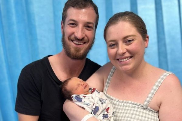 Liam and Hannah are pictured holding their newborn baby, Harry.