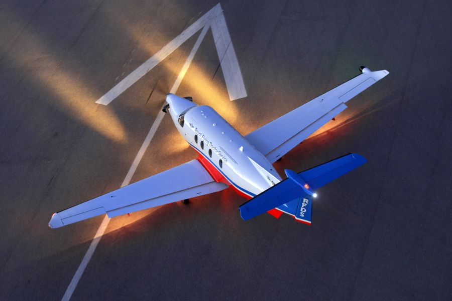 Aerial view of RFDS aircraft on a Runway at night with lights shining