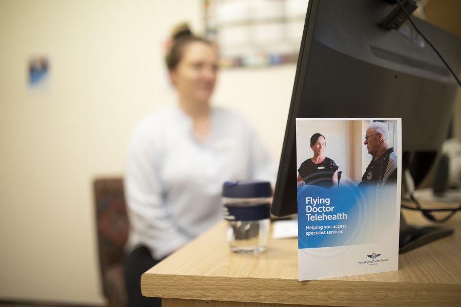 Doctor speaking to a patient with another doctor in the background on a video conference