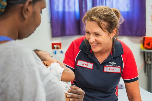 Nurse Lisa smiling at a baby in the clinic.