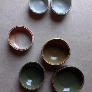 A range of stoneware bowls glazed in green, white and mustard