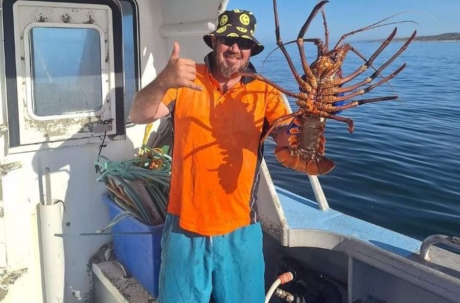 Justin smiling while holding a crayfish.