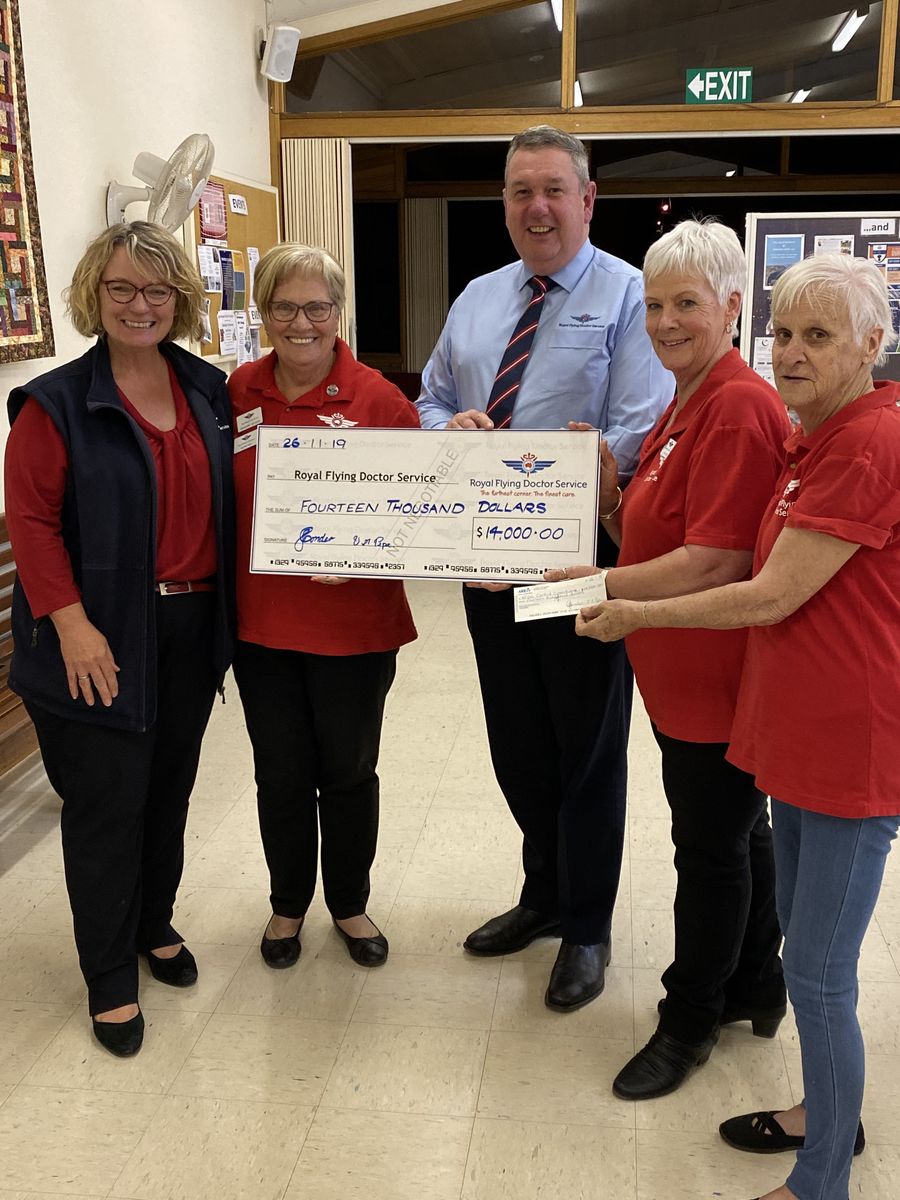 A group of people holding an oversized cheque smile at the camera. 
