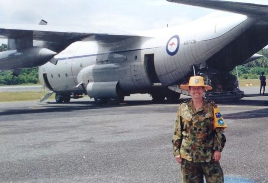 Kathleen standing infront of an aircraft in her army uniform.