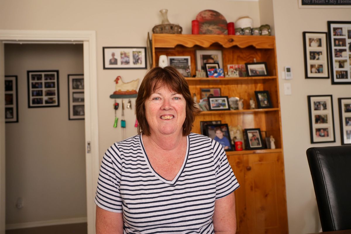Sally smiles at the camera in her home.