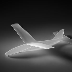 An opaque white glass model plane, resting on a plinth.