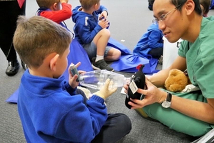 boy using spacer and ventolin with teddy
