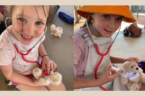 Two children are pictured holding an RFDS teddy bear, learning about wellbeing strategies.