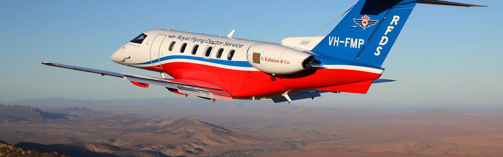 The red bottom of a jet aircraft as seen from the ground. RFDS is pained in white writing. 