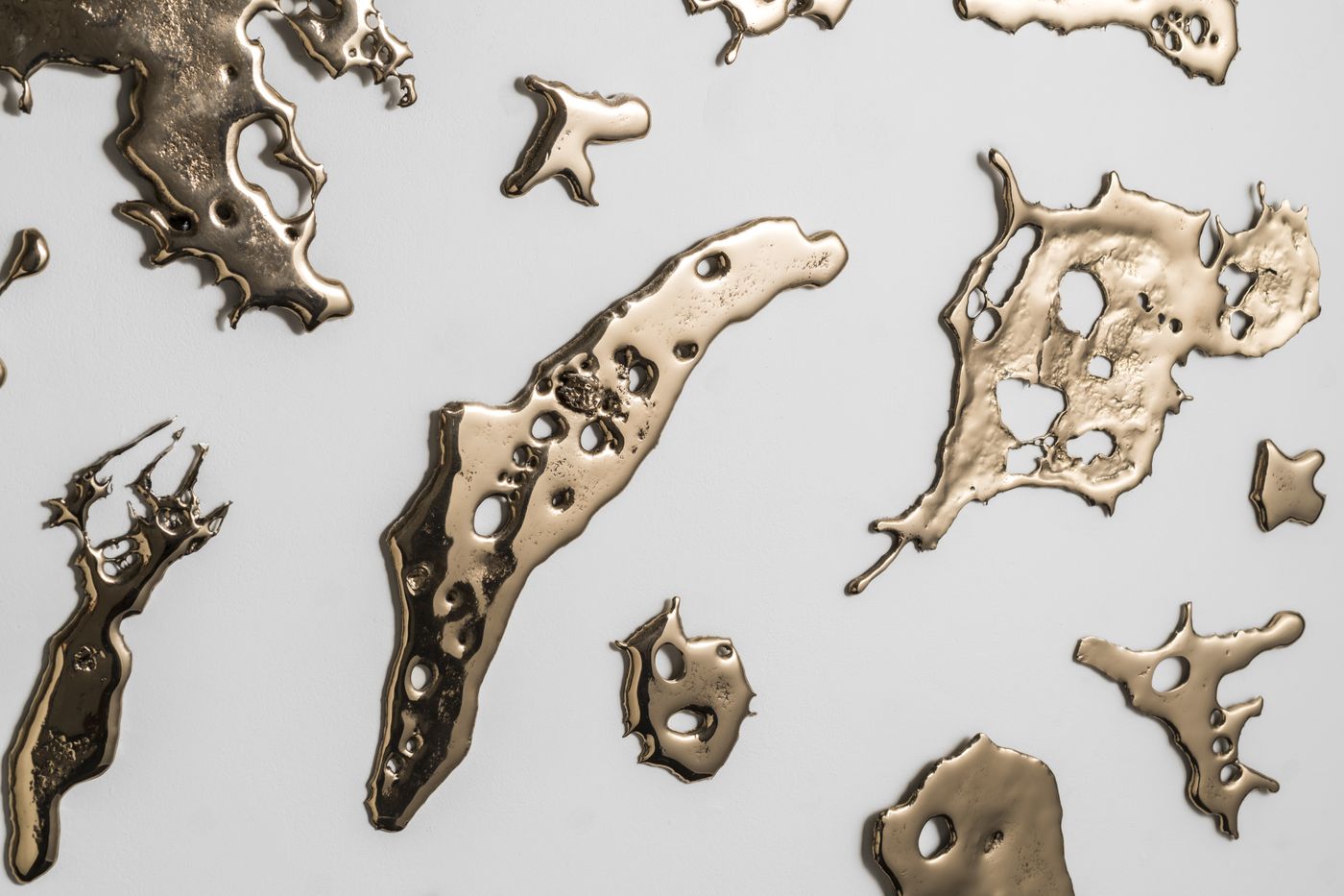 close up detail of pieces of flung bronze mounted on a wall