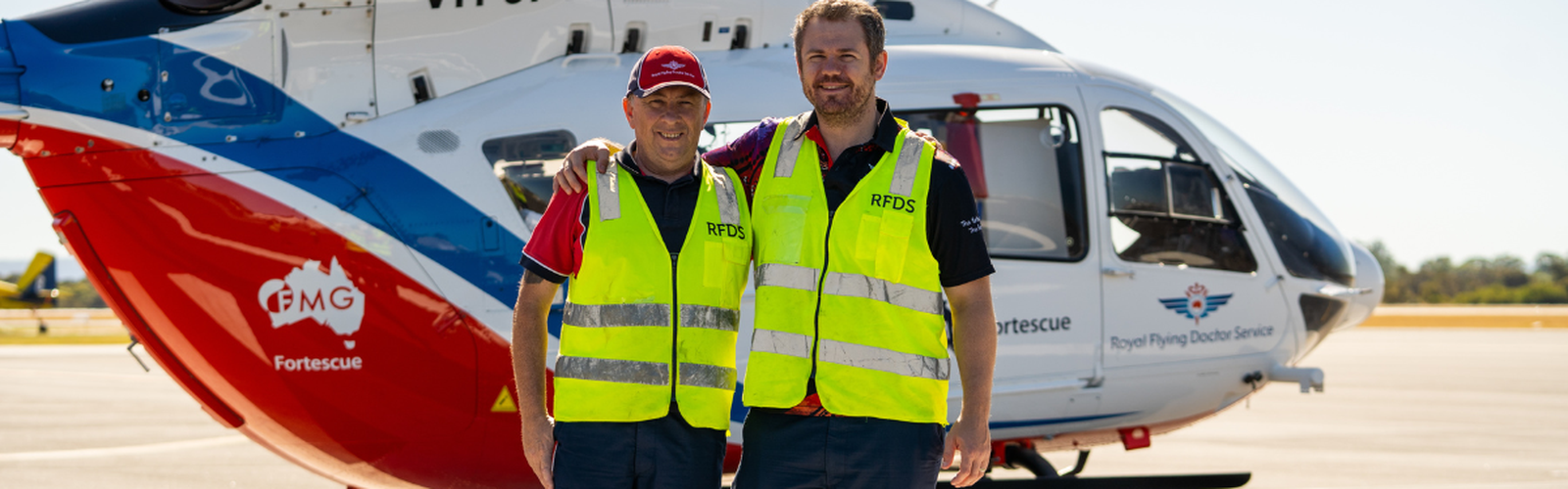 RFDS WA Pilot Jim and Doctor John pose in front of the RFDS WA FMG Helicopter