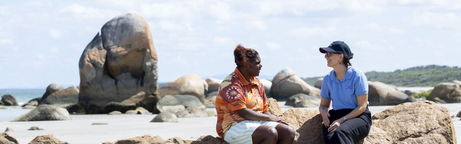 A patient talking to an RFDS staff member on the beach.