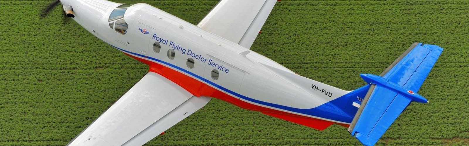 An aircraft with RFDS logo. The sun is setting. 