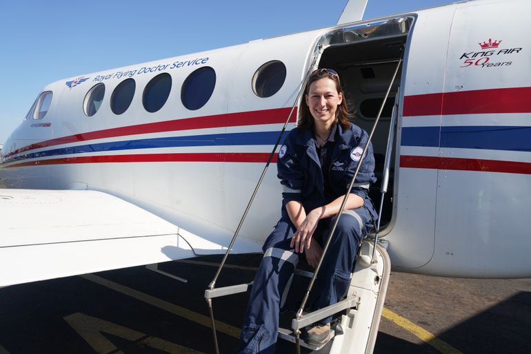 RFDS emergency retrieval specialist Dr Kiri Oats sits on stairs to RFDS aircraft