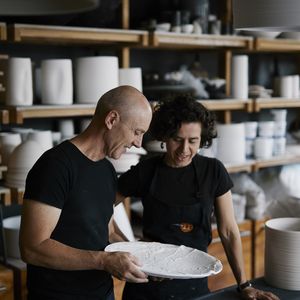 Photo of two people looking at a large round white platter