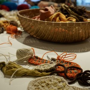 A close up of the cane basket overflowing with yarn and textile materials