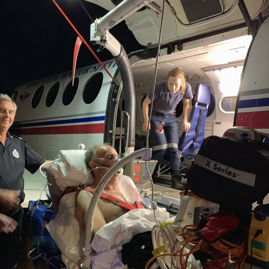 Wayne being boarded on plane