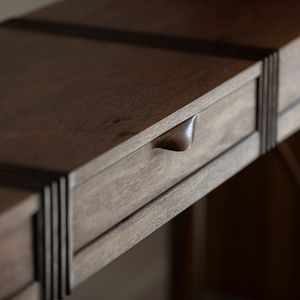Close up shot of the drawers and fluting detail of a wooden hall table