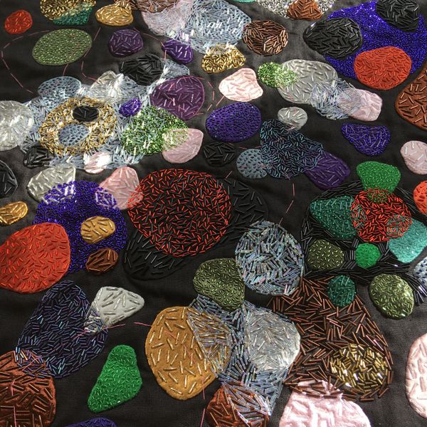 A close up image of colourful glass bead work on the artwork