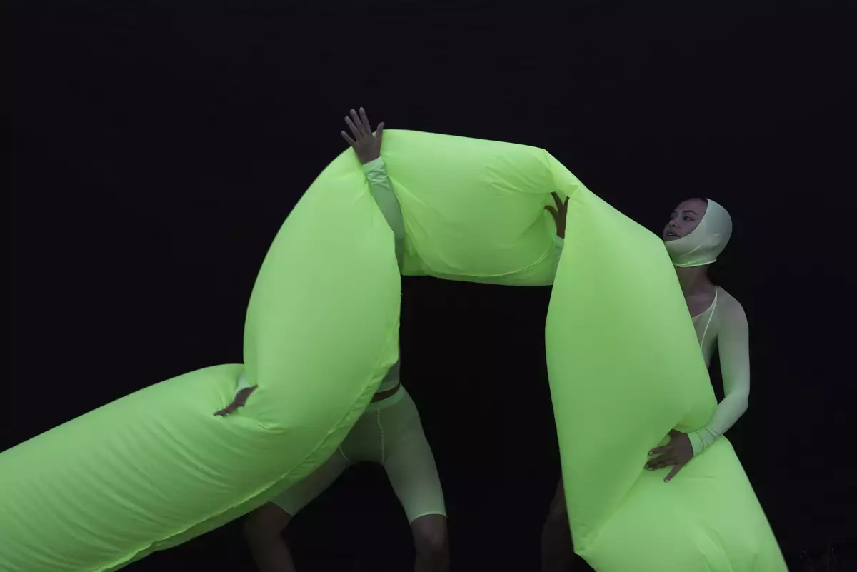 A large bright green inflatable tube held by two people