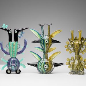 A collection of five creatures made out of glass. Each piece has a distinctive design and all pieces have the legs in the air.