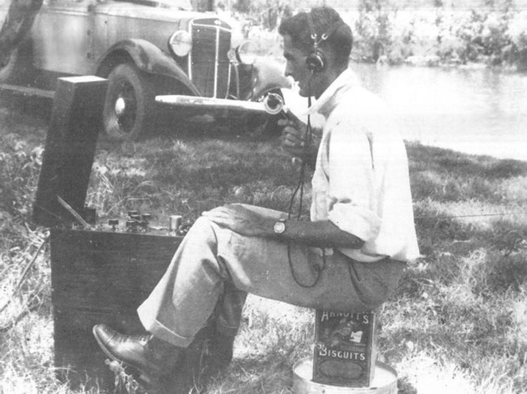 Fred McKay sits on Arnotts biscuit tin as he uses an early pedal radio