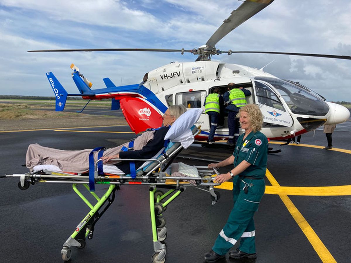 Patient pushed towards RFDS helicopter by St John's paramedic.