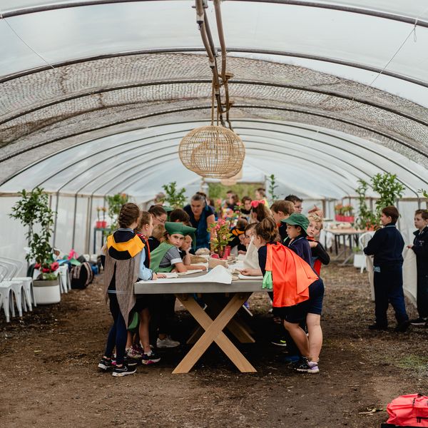 A long table full of kids under a large greenhouse dome