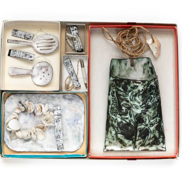 Cardboard tray with three compartments, various items made from pearl shell