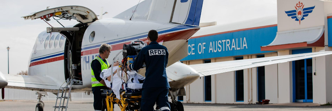 RFDS Doctors loading a patient into an RFDS Plane.